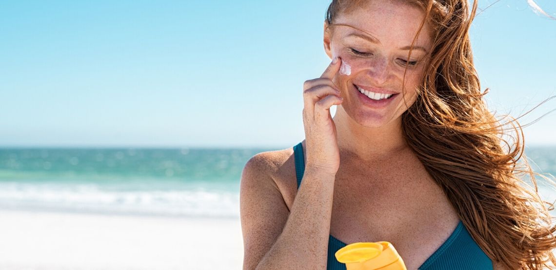 Woman putting on sunscreen