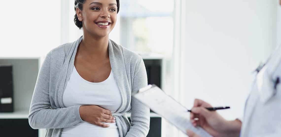 A pregnant woman meeting with her doctor