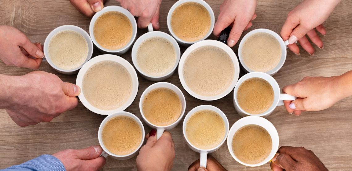 A group of people holding coffee.