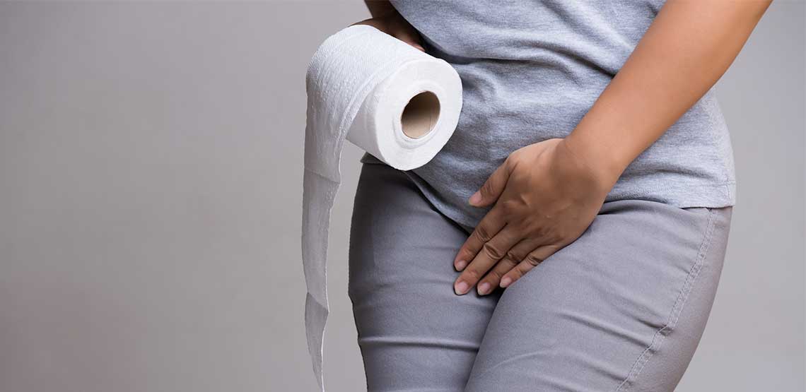 a woman holding a toilet paper roll, with a sudden urge to urinate, one of the signs of overactive bladder