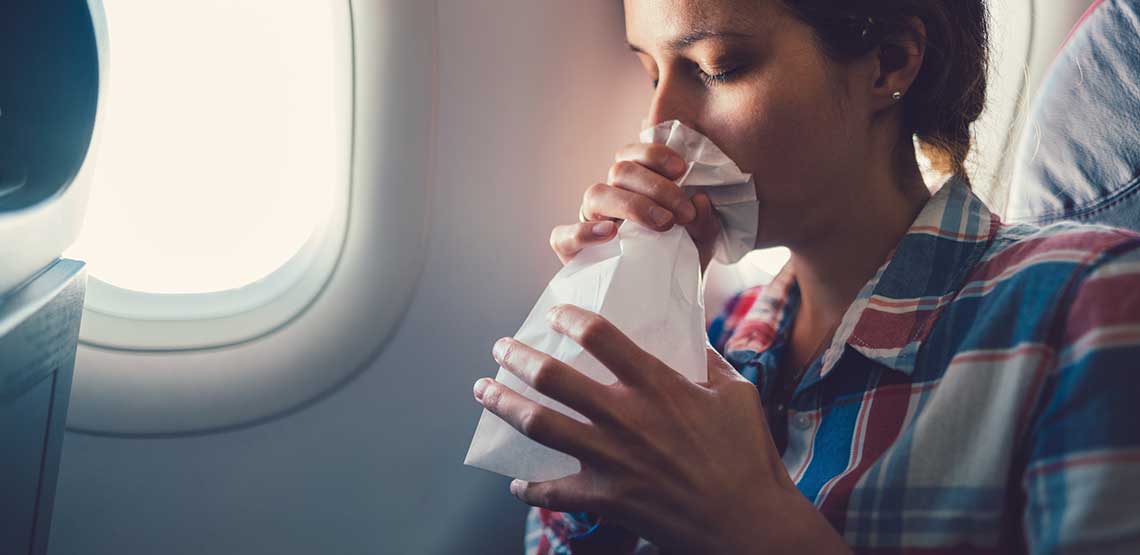 a woman feeling nauseous on a plane