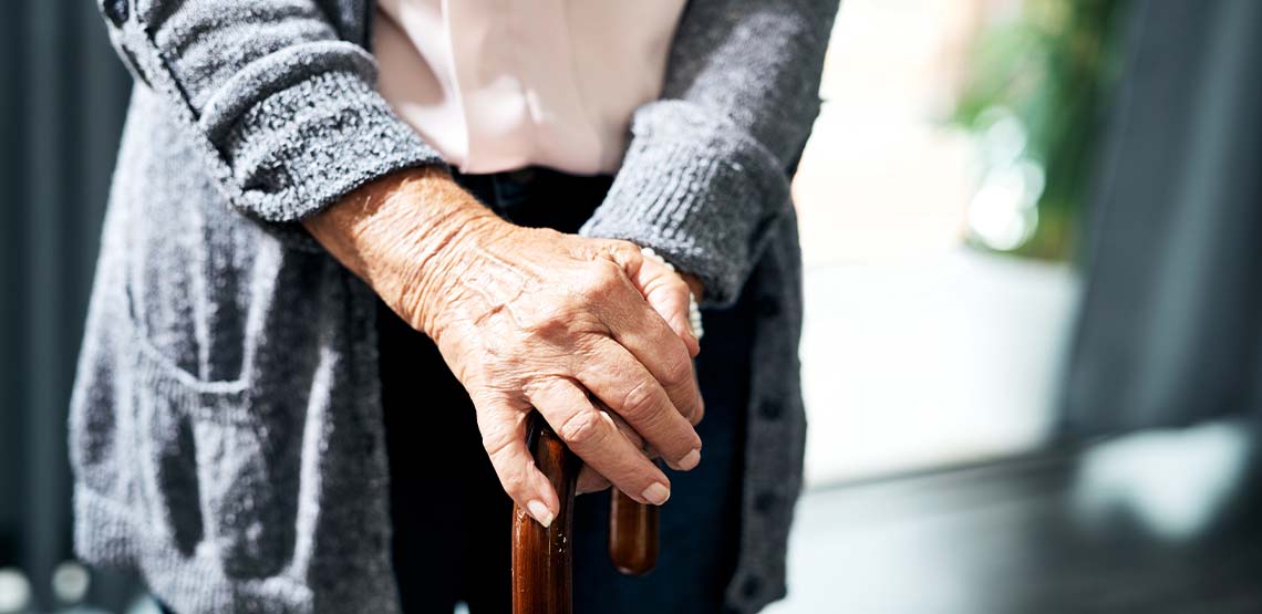 An older person holding a cane.