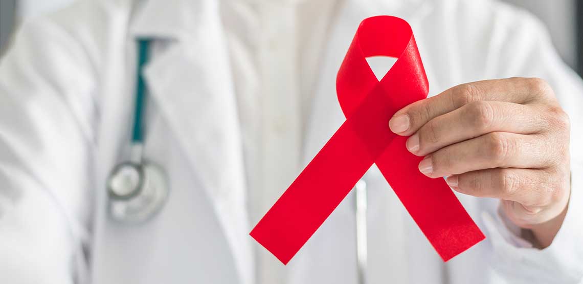 A doctor holding a red hemophilia ribbon.