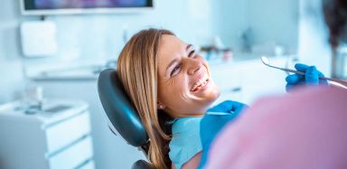 A woman smiling in a dentist chair.