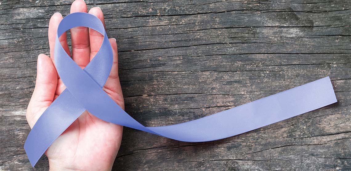 A light purple esophageal cancer awareness ribbon on a person's hand.